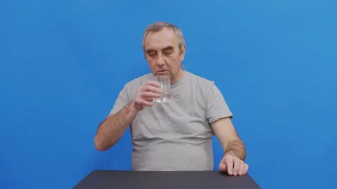 Mature man taking pill drinking water having health problem. Pensive grandfather Stock Footage 143733907