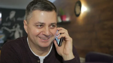 Mature man talking on the phone while sitting in a cafe. Business lunch . Cafe Stock Footage 104141004