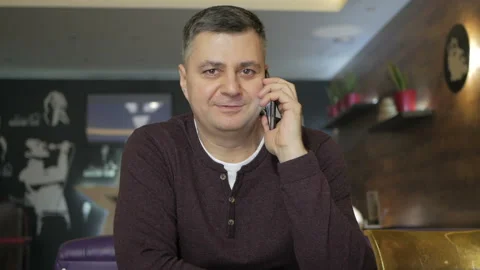 Mature man talking on the phone while sitting in a cafe. Business lunch . Cafe Video stock 104141095