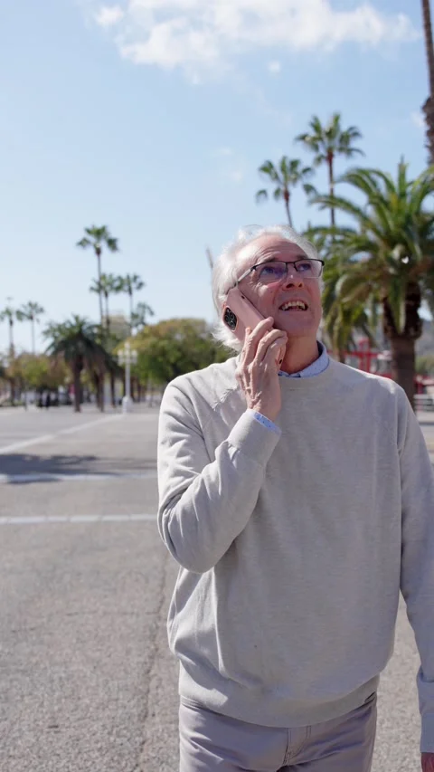 Mature man talking on phone while walking Stock Footage 269083013