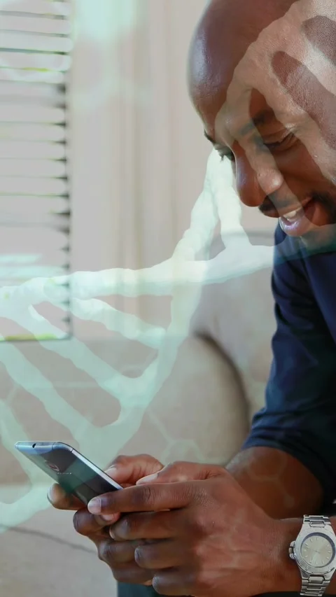 Mature man tapping smartphone on couch, revealing code and DNA helix overlay, Stock Footage 332984887
