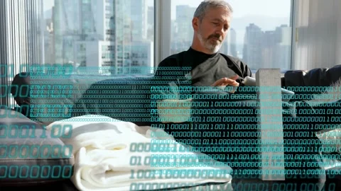 Mature man tapping tablet browsing on sofa, activating teal code overlay Stock Footage 333925238