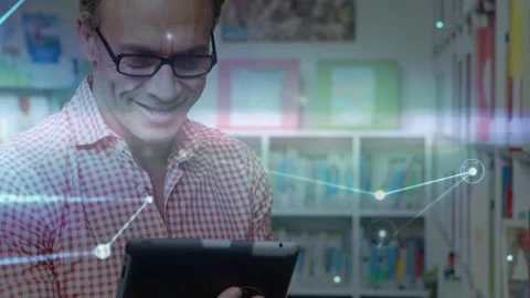 Mature man tapping tablet in library, activating network nodes and lines while Stock Footage 333287688
