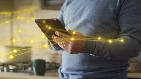 Mature man tapping tablet, syncing yellow network nodes to hand movements, Stock Footage 333873750
