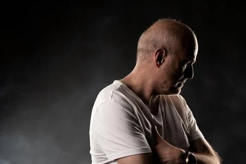 Mature man thinking with pensive expression and dramatic lighting Stock Photos