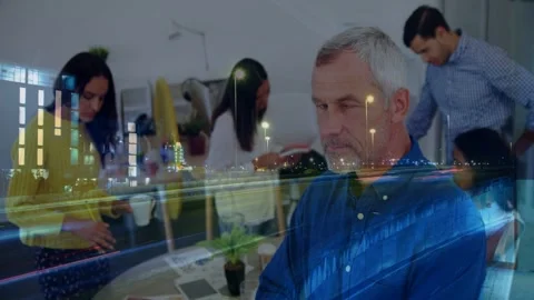 Mature man turning to camera and smiling as office team gathers checking phone Stock Footage 332566283