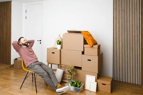 Mature man unpacking things from boxes while moving in new apartment. Stock Photos