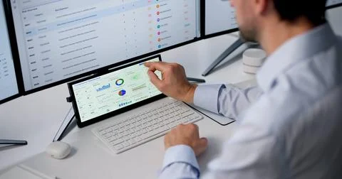 Mature Man Uses Computer Screen To Monitor Risk Management Dashboard. Stock Photos