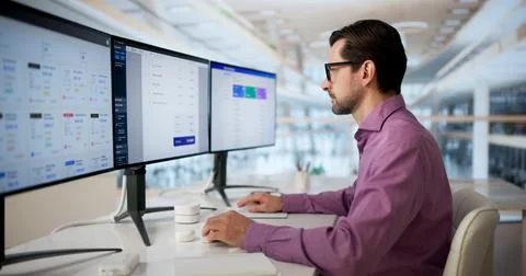 Mature Man Using Computer Software To Automate Billing And Payroll Tasks. Foto stock