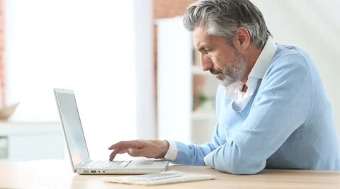 Mature man using laptop at home Stock Footage