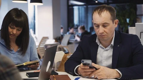Mature man using smartphone and working in office Stock Footage 113632715