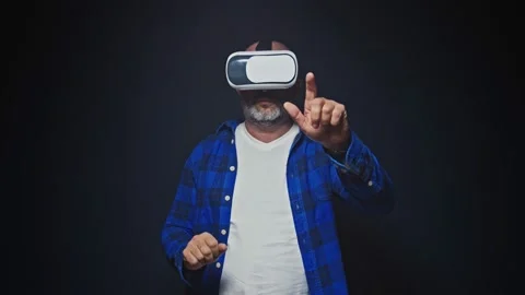 Mature man using VR headset for virtual reality in studio Stock Footage 147729042