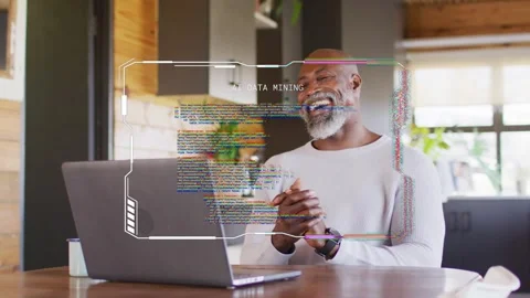 Mature man viewing laptop for tech work, smiling laughing while HUD over screen Stock Footage 333478113