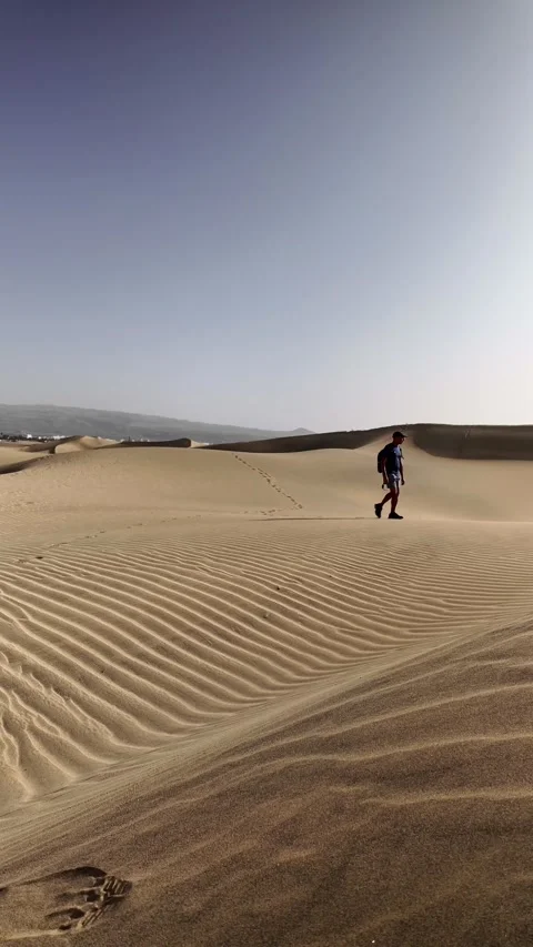 Mature man walking alone across the desert sand dunes Stock Footage 345093134
