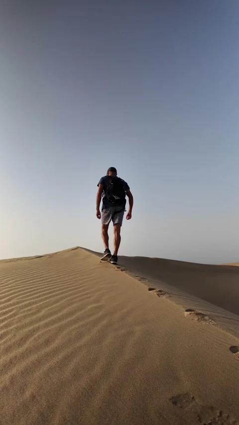 Mature man walking alone on a desert sand dune Stock Footage 345093163