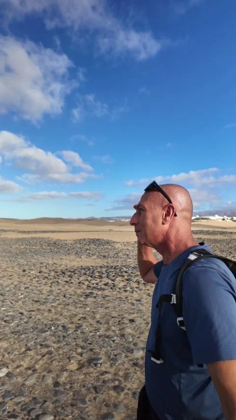 Mature man walking alone in a desert landscape Stock Footage 346177559