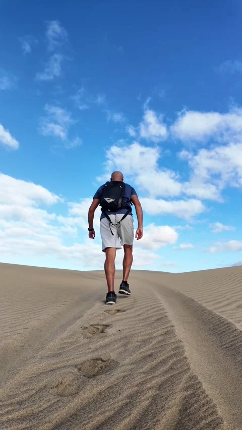 Mature man walking alone on a desert sand dune Stock Footage 346177621