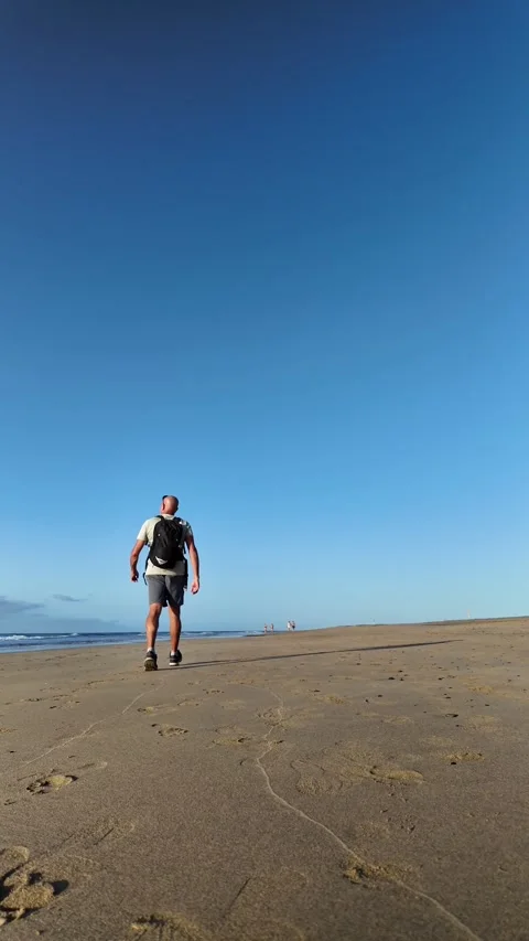 Mature man walking on a sandy beach for mental wellness Stock Footage 345839105