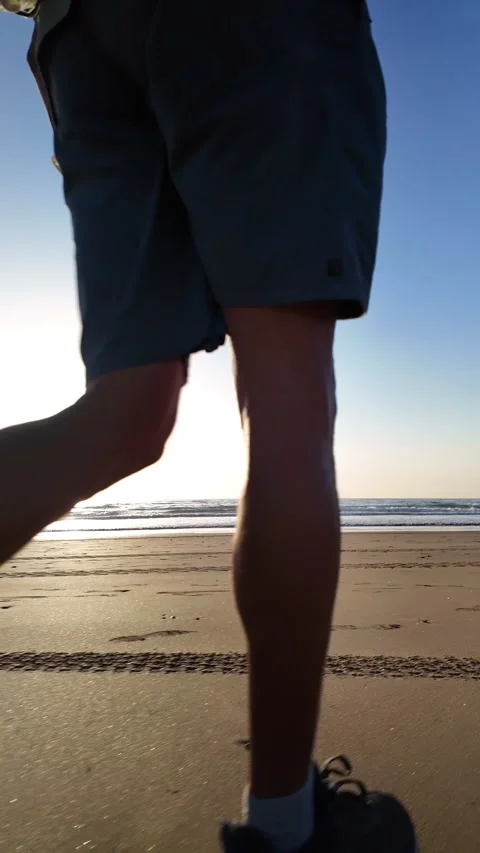 Mature man walking on a sandy beach at sunrise Stock Footage 345839253
