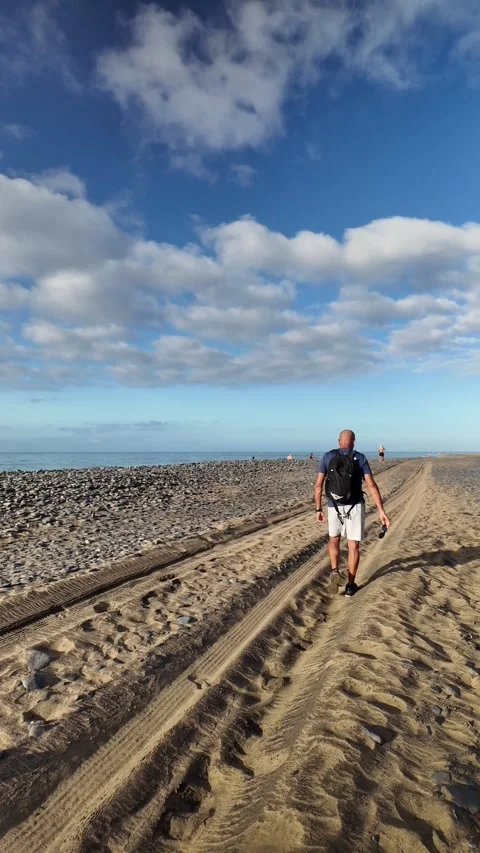 Mature man walking on a sandy beach in the morning Stock Footage 346177544