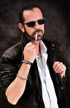 Mature man without complexes posing before the camera smoking Fotos de archivo