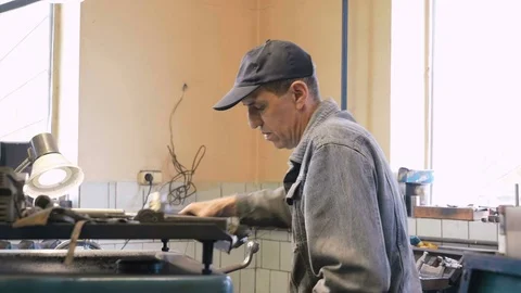 Mature man working on cylindrical boring of connecting rod bushing on old lathe. Stock Footage 81508433