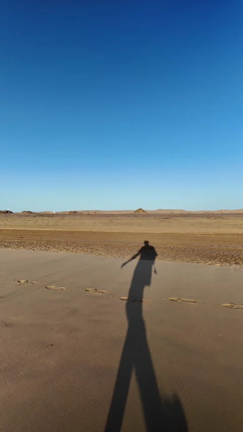 Mature man's shadow walking on a sandy beach Stock Footage 345839104