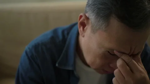 Mature old man gray-haired headache hands rubbing eye sitting on sofa. Portrait. Stock Footage 265642018