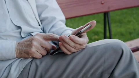 Mature older middle aged old adult holding cellphone scrolling and texting Vídeos de archivo 336249854