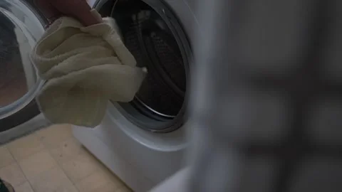 Mature person hand loading used clothes inside of open washing m Video stock 221779720