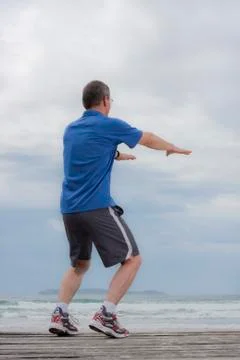 Mature runner doing squats Stock Photos