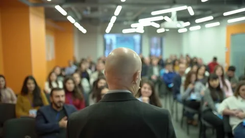 Mature self-confident,talking man in front of an audience at a forum, conference Stock Footage 198518443