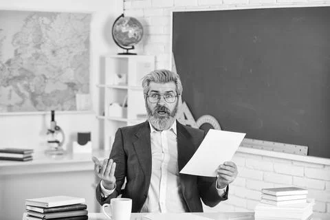 Mature smart educator. Knowledge day. Man school teacher sit in classroom 写真素材