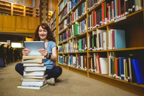 Mature student in library using tablet 스톡 사진