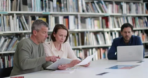 Mature students in library studying together Stock Footage 86484047