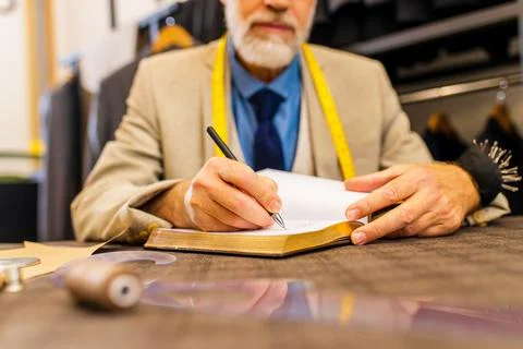 Mature tailor working with sewing pattern in atelier Stock Photos