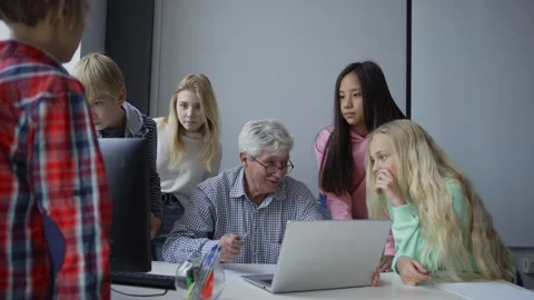 Mature teacher with students using computer and discussing study project Stock Footage 142496763
