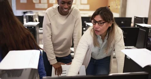 Mature teacher working with multiracial students inside computer classroom Vídeos de archivo 168622952
