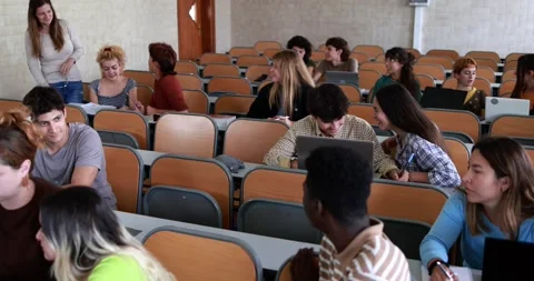 Mature teacher working with students inside classroom at school university Stock Footage 203726486