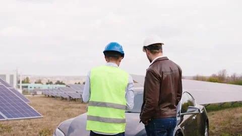 Mature two ecological workers at modern solar panels farm discussing about Stock Footage 164543885