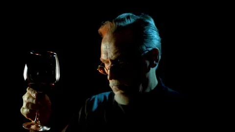 Mature winemaker checking color, quality, and sediments of wine Stock Photos