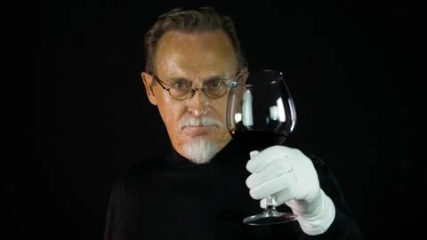 Mature winemaker checking color, quality, and sediments of wine Stock Photos