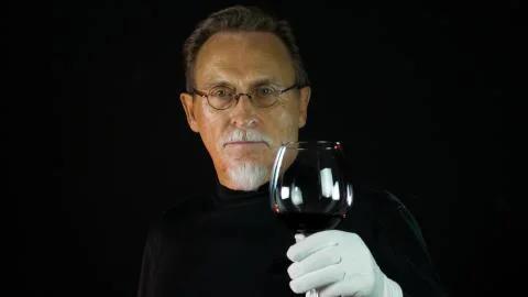 Mature winemaker checking color, quality, and sediments of wine Stock Photos