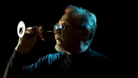 Mature winemaker checking color, quality, and sediments of wine Stock Photos