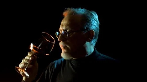 Mature winemaker checking color, quality, and sediments of wine Stock Photos