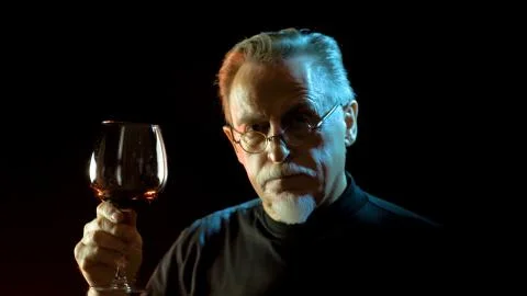 Mature winemaker checking color, quality, and sediments of wine Stock Photos