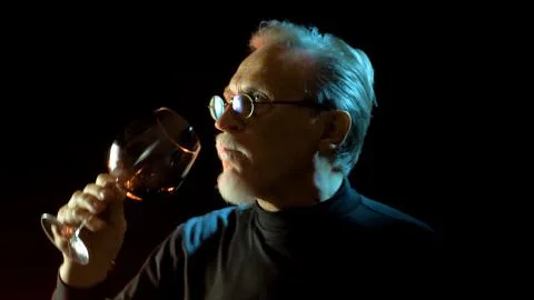 Mature winemaker checking color, quality, and sediments of wine Stock Photos