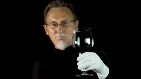 Mature winemaker checking color, quality, and sediments of wine Stock Photos