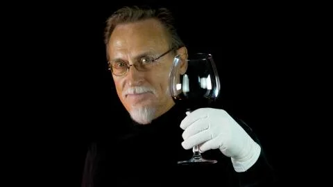 Mature winemaker checking color, quality, and sediments of wine Stock Photos