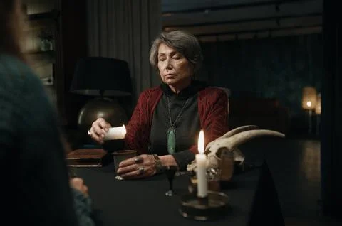 Mature witch reading spell for client Foto stock